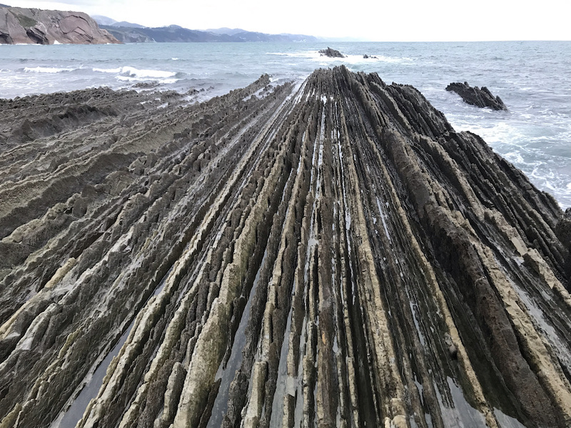 Sterk geribbelde rotsformaties die bij Zumaia aan de Costa Vasca in zee verdwijnen