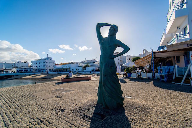 Een vrouw op uitkijk naar de vissersboten in Corralejo Viejo op het Spaanse eiland Fuerteventura