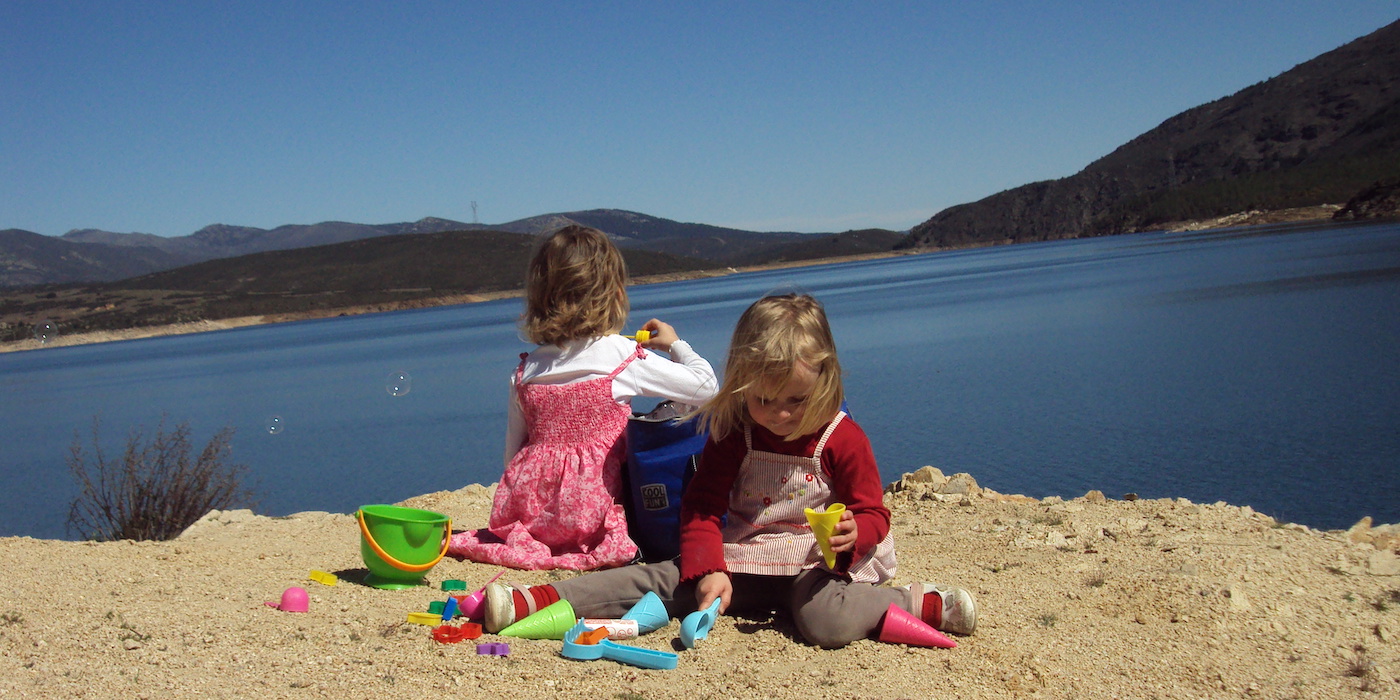 Kinderen spelen bij Berrueco bergmeer in regio Madrid (Spanje)