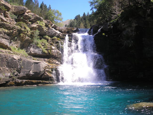 Een waterval die uitkomt in een helderblauw bergmeer in nationaal park Ordesa y Monte Perdido in de Pyreneeën van Aragon in Noord Spanje